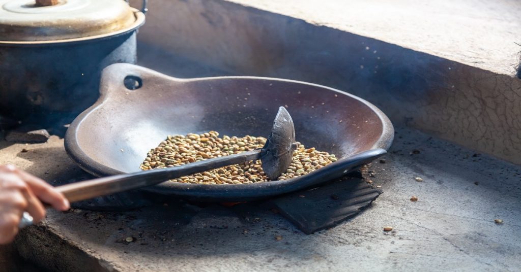 Indonesia traditional roasting fresh coffee beans in a skillet
